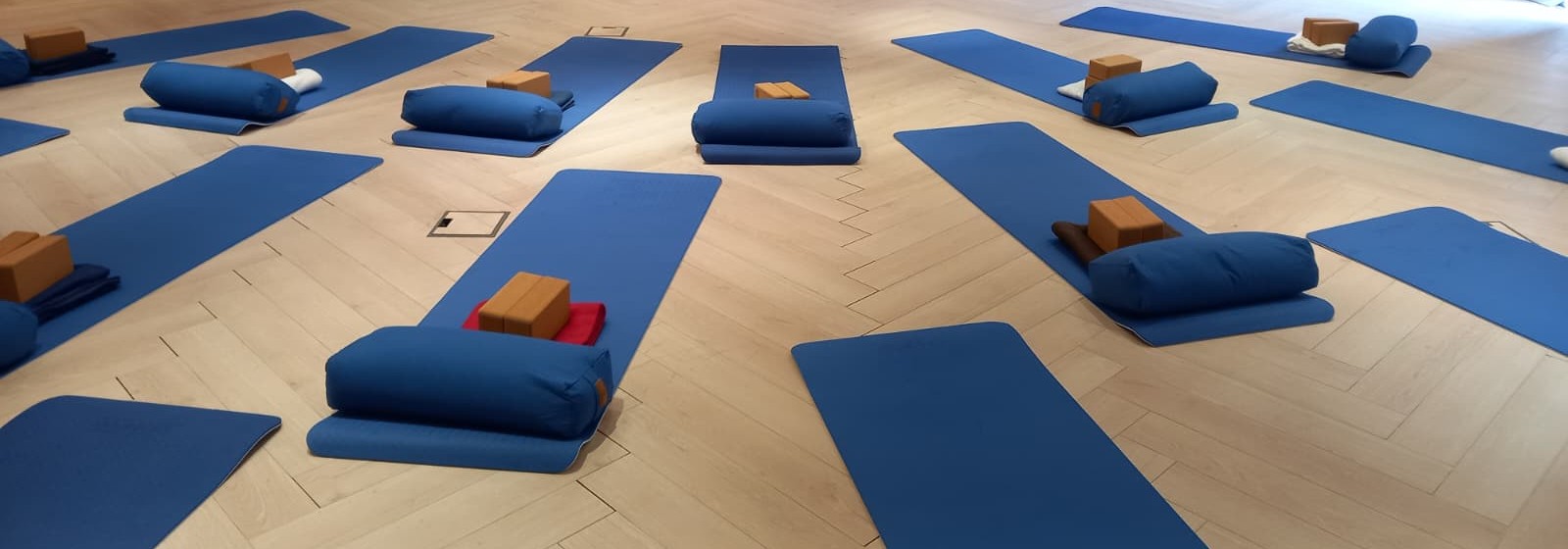 Vorbereitete Yogamatten mit Bolstern und Blöcken